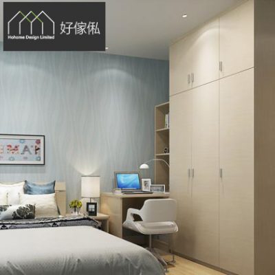 淺藍色睡房實景，右邊一排到頂淺木色拉門衣櫃接住轉角書枱，枱面有手提電腦，配白色現代造型椅同開放式書架，左邊放雙人床、藍灰色床品同床頭燈，牆身藍色水波紋牆紙。