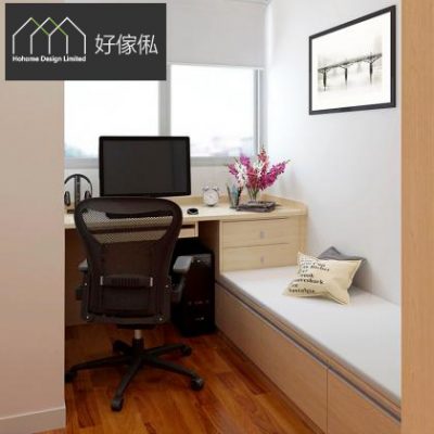 細書房沿窗訂造淺木色工作檯，枱面擺電腦顯示器、小鬧鐘同一束紫色假花，枱下連兩層抽屜，黑色網背辦公椅，右邊接駁鋪白色軟墊嘅窗台坐臥位放文字圖案抱枕，牆上掛黑框裝飾畫，地下深木紋地板。