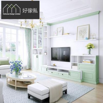 客廳電視牆方形展示圖，薄荷綠白色電視櫃連兩側到頂書櫃同層架，電視上方白色擱板擺掛畫同花瓶，左側玻璃窗引入綠景，金色吊燈下放木腳橢圓茶几、淺色梳化同長條腳踏，地下鋪幾何地氈。