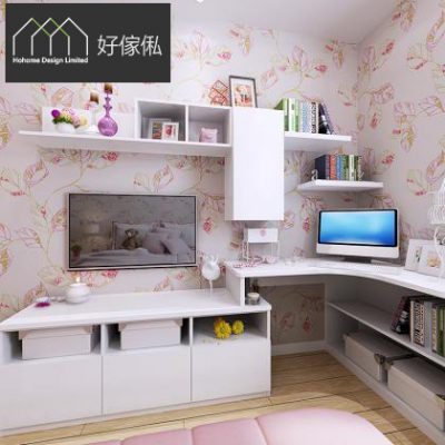 白色轉角組合傢俬，下方矮櫃放平面電視連儲物抽屜，上方兩層掛牆層架同白色吊櫃擺相架書本，右邊L形書枱放電腦顯示屏連鍵盤，枱下開放格放書，背景粉色花卉牆紙。