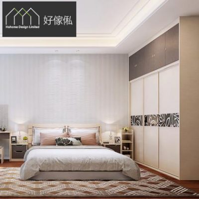 主人房實景訂造傢俬，中央一張雙人床鋪灰白床品配粉啡枕頭及花紋抱枕，兩側白色床頭櫃連枱燈，右邊一組到頂趟門衣櫃中央嵌黑白葉紋玻璃飾條，上方啡色頂櫃，深木地板配幾何地毯，畫面有好傢俬 HoHome 標誌。