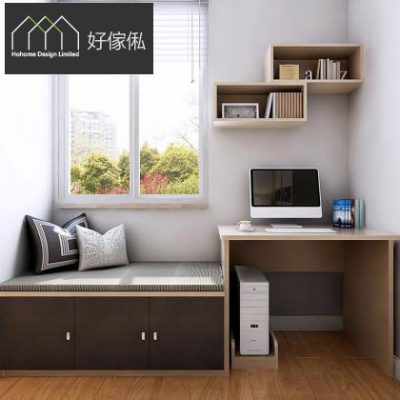窗邊訂造榻榻米地台連書枱近景，深啡色雙門櫃身配灰色長坐墊貼窗而設，墊上放黑白幾何同灰色花紋抱枕，右邊淺木辦公書枱擺白色一體電腦及書本，枱下放電腦主機，牆上兩格淺木吊櫃放書同擺設，窗外見綠樹同樓景，木紋地板。
