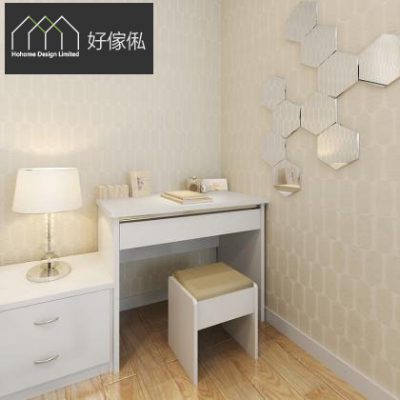 睡房梳妝角成圖，白色梳妝枱面放檯燈、首飾盒同書本，配一張白色金啡軟墊化妝椅，左邊接駁白色床頭櫃連兩層抽屜，右邊牆身貼六角形菱格鏡，淺色幾何牆紙配淺木紋地板，左上角有好傢俬 HoHome 標誌。