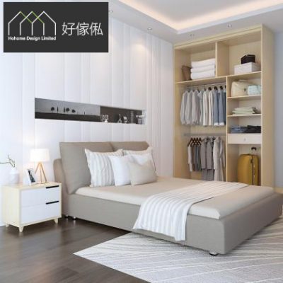 北歐風睡房，右邊衣櫃打開露出內部設計:上方層板放摺好嘅毛巾同收納盒，中間鐵通掛住一排淺色恤衫，右下角放黃色行李篋;左邊係灰啡色布藝雙人床配白被鋪，白色雙抽床頭櫃上有綠葉裝飾，木地板鋪淺色地氈。