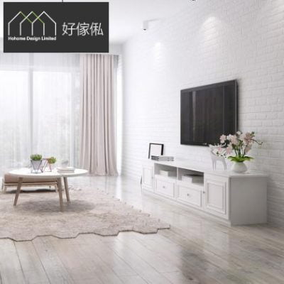 明亮客廳場景，右邊白磚牆掛黑色電視，牆下擺白色矮身電視櫃連兩個抽屜同開放格、枱面有插花;左邊圓形木腳茶几同單椅，落地淺色窗簾透入自然光，淺色木地板鋪住毛地毯。