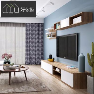 客廳實景相，藍色主題牆掛起大電視，下方係木紋連白色電視矮櫃連開放格，右上方懸空木格吊櫃放擺設，前方一張木腳圓茶几配地毯，旁邊放青色花瓶同仙人掌，淺木地板。