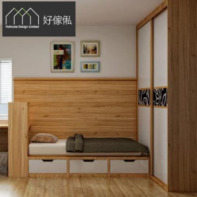 睡房角落實景，木色榻榻米床鋪米色床墊同灰綠被、印花枕頭，床頭做木紋高側板，床下白色大抽屜，右側木色趟門衣櫃配黑色花紋玻璃飾條，後方木紋牆板上掛三幅裝飾相框。