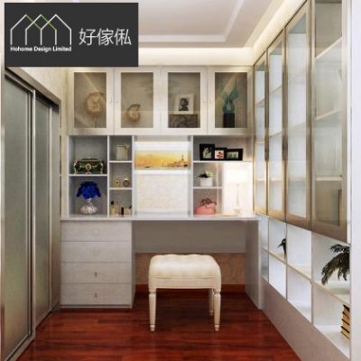 睡房梳妝角訂造白色梳妝枱連抽屜，枱面放化妝品、檯燈同藍色花藝，上方玻璃門吊櫃連開放分格擺相架擺設，配白色軟墊妝凳，左側趟門衣櫃、右側玻璃門高櫃，啡色木地板，左上角為好傢俬 HoHome 標誌。