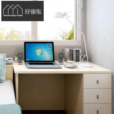 淺木色L形電腦枱近景，枱面放着開機的手提電腦、兩個喇叭、咖啡杯同一排書籍，配白色座枱檯燈，右邊枱櫃設三個灰拉手櫃桶，後方窗戶裝白色百葉簾望出綠景，左邊見床邊一角，淺木同淺藍色調。