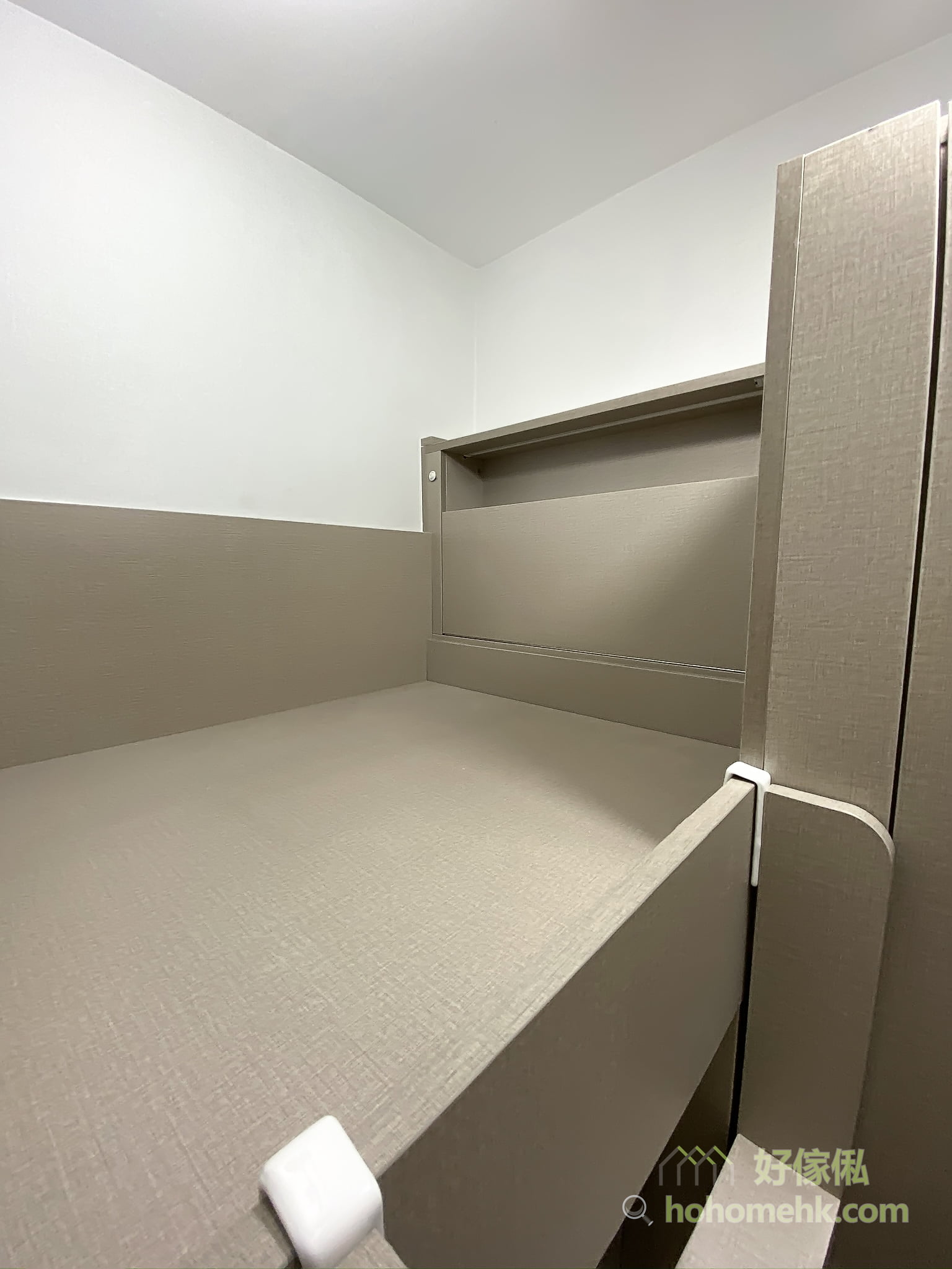 組合床上格床嘅睡眠平台，床板鋪灰米色麻質紋面料，床頭牆身做咗一格橫向凹入式開放層架，上半牆係白色、下半牆係灰啡色，床邊裝有白色防跌扣件。
