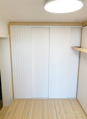 全白色的衣櫃趟門，其中一半採用條子門板設計，簡單得來一點也不單調