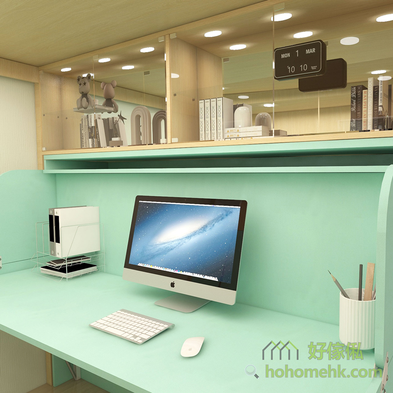 兒童屋仔床書枱電腦配置近景，翠綠色書枱枱面上放一體式電腦、鍵盤、滑鼠、文件架及白色筆筒，上方玻璃書架背壁鏡面，展示公仔書本及翻蓋時鐘，天花嵌入圓形LED射燈多個，整體翠綠色