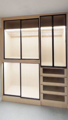 黑色鋁框包覆著水紋玻璃，再配上原木色的櫃身，加上LED燈的點綴，衣櫃再也不是黑漆漆、找不到衣服的傳統衣櫃，而是內外兼備的現化風玻璃門衣櫃了。