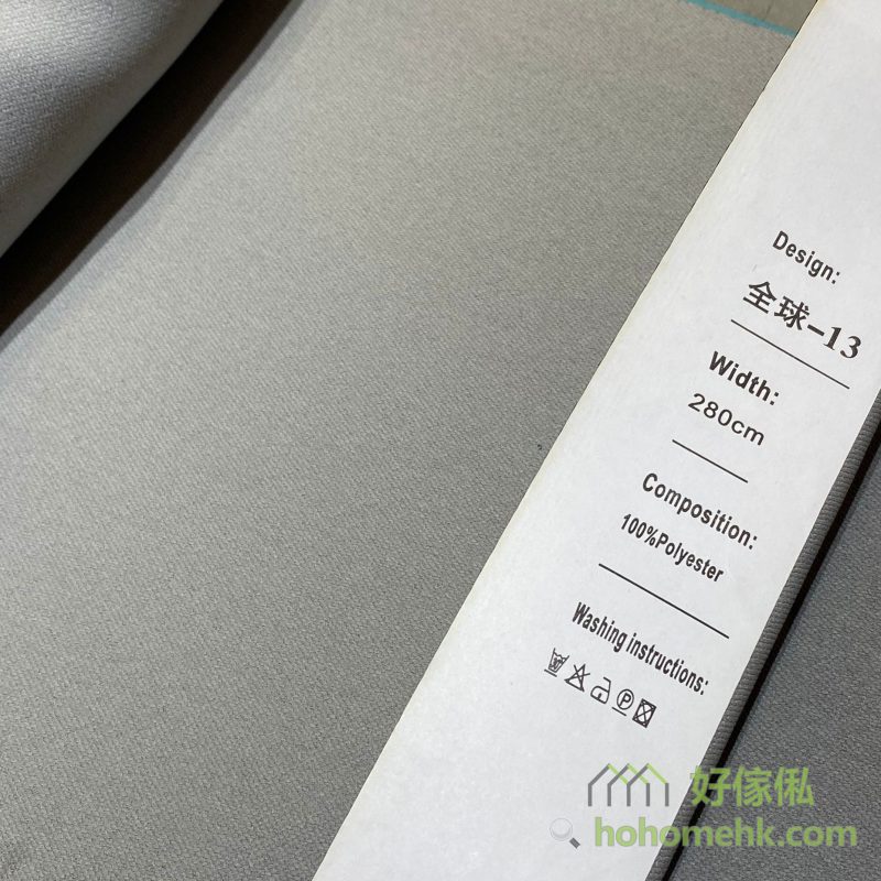 斜紋平板布窗簾13號色布料近距特寫，標籤顯示「全球-13」及100%Polyester，布面呈細密斜紋素色設計