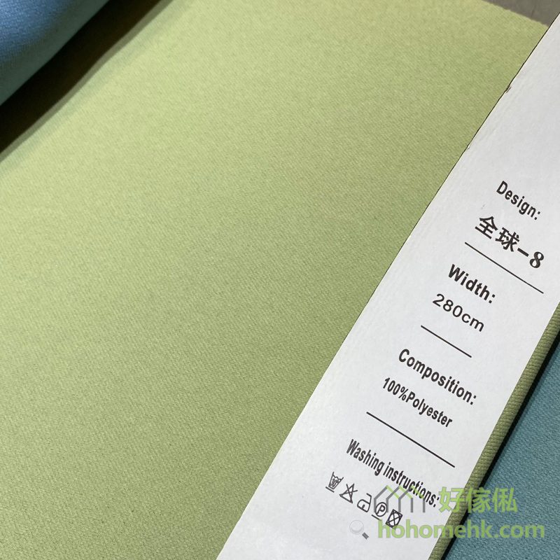 斜紋平板布窗簾8號色布料近距特寫，標籤顯示「全球-8」及100%Polyester，布面呈細密斜紋素色設計