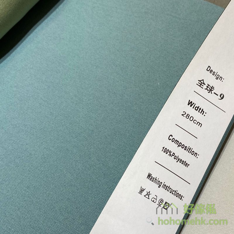 斜紋平板布窗簾9號色布料近距特寫，標籤顯示「全球-9」及100%Polyester，布面呈細密斜紋素色設計