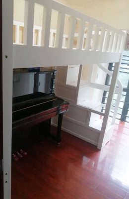 Physical photo: Clean white bed frame + stair cabinet (ladder on the right)