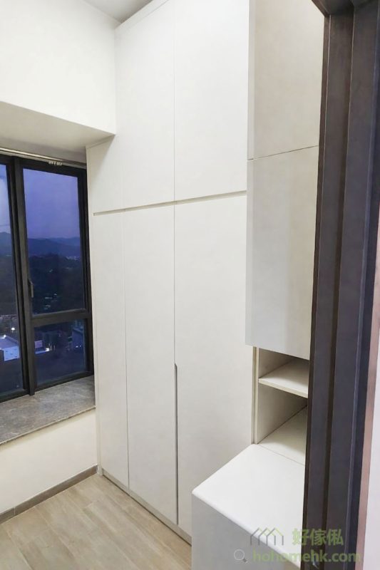 衣帽間以淺灰色櫃體為主，搭配玻璃門設計，提升通透感之餘，也方便展示香水及飾物等精品。內部布局合理，將掛衣區與儲物格巧妙結合，讓空間利用率達到最高，滿足日常收納需求之餘，還保有高質感的視覺效果。