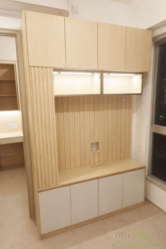 客廳的電視櫃採用原木條子格柵設計，為整體增添一絲日式禪意。櫃內還設有兩格玻璃飾櫃，方便擺放喜愛的飾品或收藏品，既能增添空間層次感，亦讓生活更有品味。