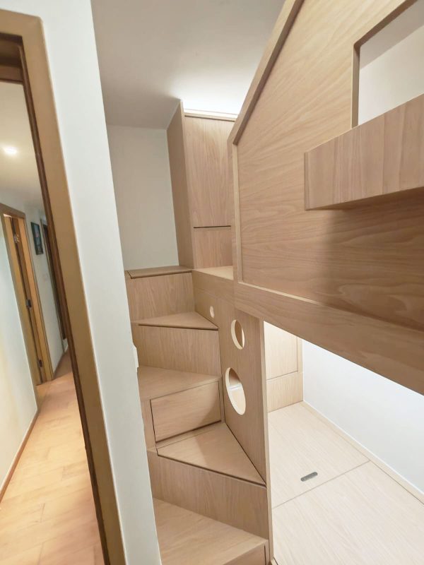 我們的設計不但考慮到儲物功能，還在細節上提升用戶體驗。樓梯櫃提供了額外的儲物空間，還巧妙地成為下床的屏風，增強下床位置的私隱度。每個樓梯都經過精心設計，兼顧實用和美觀，是小空間內不可多得的亮點，因為空間有限，所以每級樓梯做成三角形錯開的排列，用更少的空間就做到容易上落的樓梯櫃。