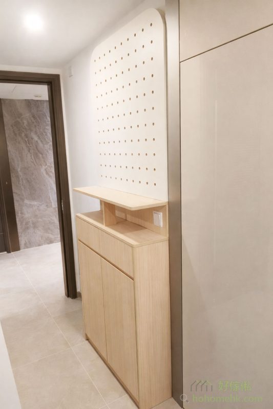 為了一進門就感受到整潔與美觀，我們的設計師特別為客戶設計了一款半腰鞋櫃，櫃頂搭配時下流行的到頂洞洞板。不但提供充足的收納空間放鞋，洞洞板還可以靈活掛放家居用品或裝飾物，讓門口成為展示個人風格的小角落。