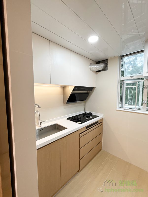 將煮食爐設置在窗邊，不僅讓油煙機的氣喉能採用更短的路線直接通往室外，還能節省吊櫃內部的空間，增加收納的靈活性。這種設計充分利用了日式廚房強調的實用性原則，保證烹飪空間的整潔與高效運作，而吊櫃的精心佈局則為儲物提供更多可能。