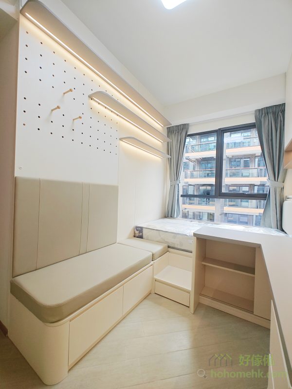 一面牆身訂造成洞洞板設計，既能與其他家具的顏色保持一致，又能靈活調整層板的長度與深度，滿足不同的展示與收納需求。無論是擺放書本、裝飾品，還是日常用品，洞洞板都能讓空間利用率達到最大化，同時保持整潔有序。