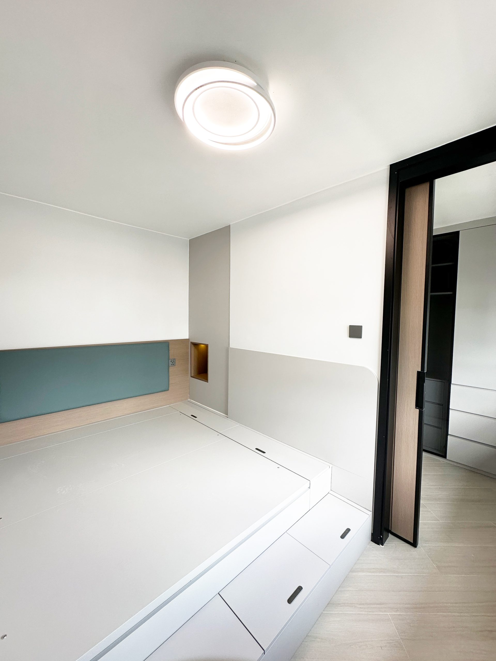 進入主人房，首先吸引目光的是大容量油壓床。床板下方擁有充裕的儲物空間，適合存放大型床品和季節性物品。而床頭的內嵌式設計，配合燈效，夜間使用更添溫馨。