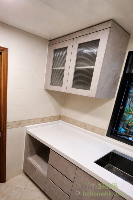 無論廚房面積大小，高低級廚櫃都能巧妙融合實用功能與美觀外觀，例如透過灰色大理石紋門板營造時尚感。石英石枱面不僅耐用、不食色，還容易清潔，結合玻璃櫃門的細節，使廚房設計顯得格調非凡。