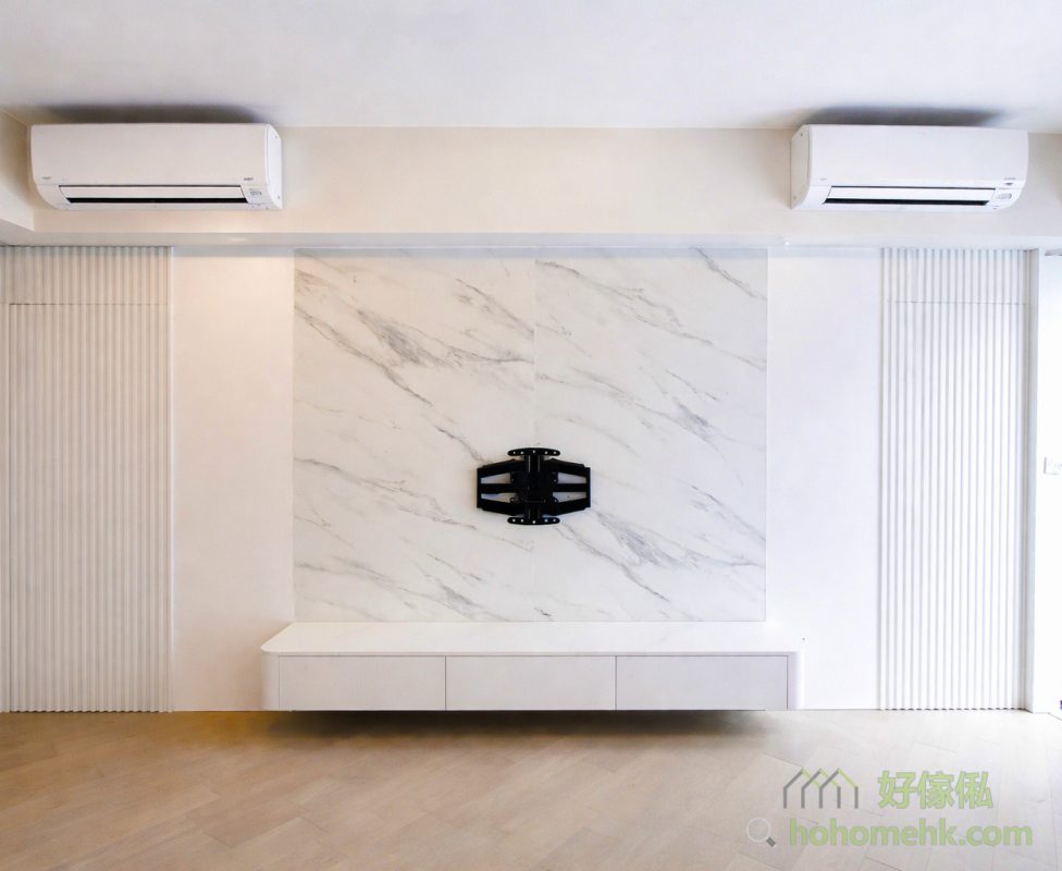 訂造電視櫃時，背景牆設計絕對是不容忽視的重點。背景牆不僅在視覺上成為客廳的焦點，更能利用隱形門設計，巧妙將走廊及房門隱藏起來，令整體空間看起來更加整潔一致。同時，搭配白色大理石紋理板材，為客廳增加高貴時尚的感覺。