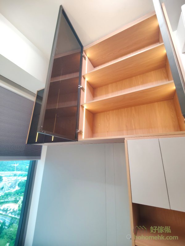 為提升整體空間氛圍，我們在床頭及展示櫃內加入LED燈帶設計。光線柔和，既能作為日常照明，也為整體家居營造出溫馨舒適的感覺，足見設計師對細節的用心。床尾吊櫃的黑玻璃櫃門與燈光的搭配，更為空間增添一份高級感。