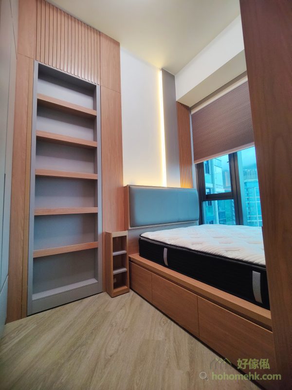 為提升整體空間氛圍，我們在床頭及展示櫃內加入LED燈帶設計。光線柔和，既能作為日常照明，也為整體家居營造出溫馨舒適的感覺，足見設計師對細節的用心。床尾吊櫃的黑玻璃櫃門與燈光的搭配，更為空間增添一份高級感。